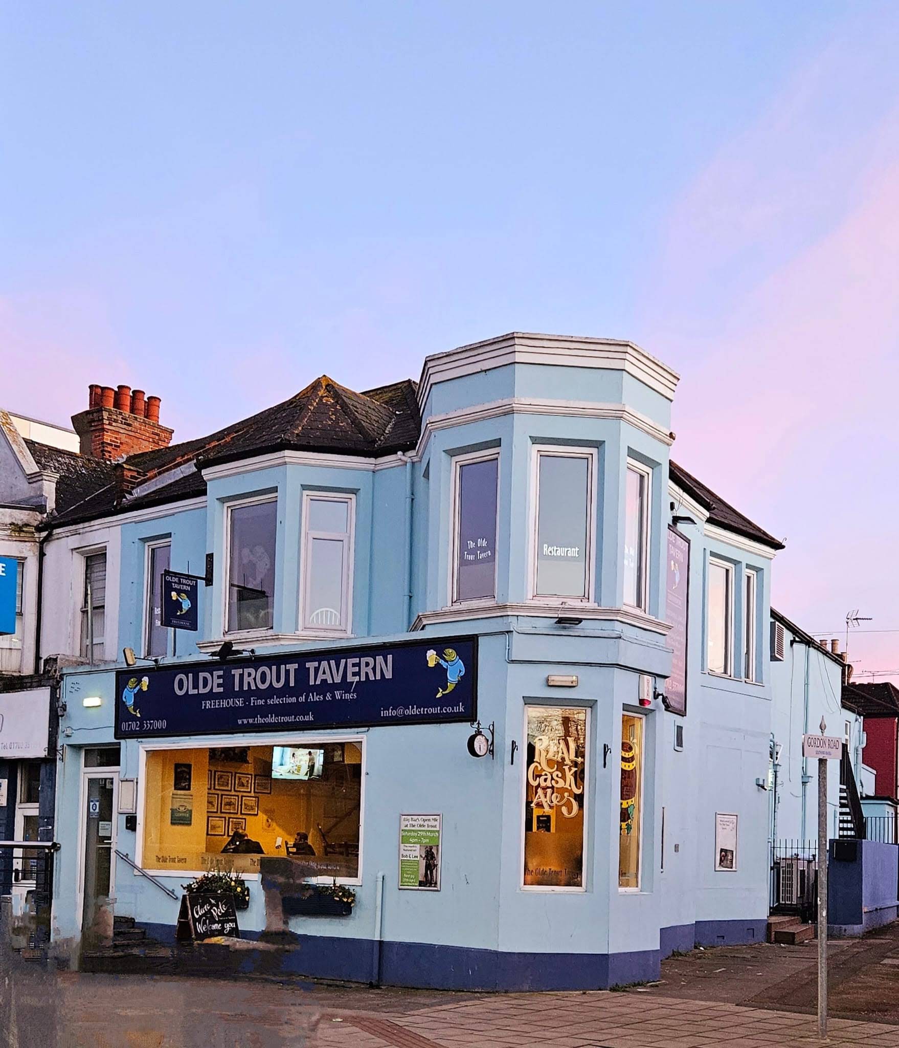 The real blue corner building of The Olde Trout Tavern, with its sign and entrance